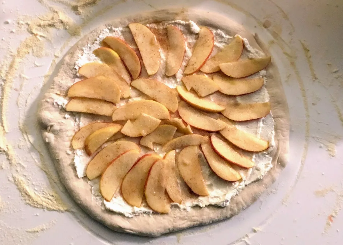Abbildung einer belegten, noch nicht gebackenen Apfel-Zimt-Ricotta-Pizza